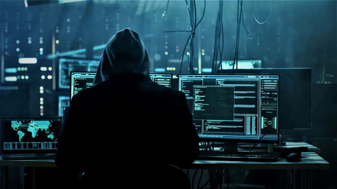 Person with hoodie works in front of computer