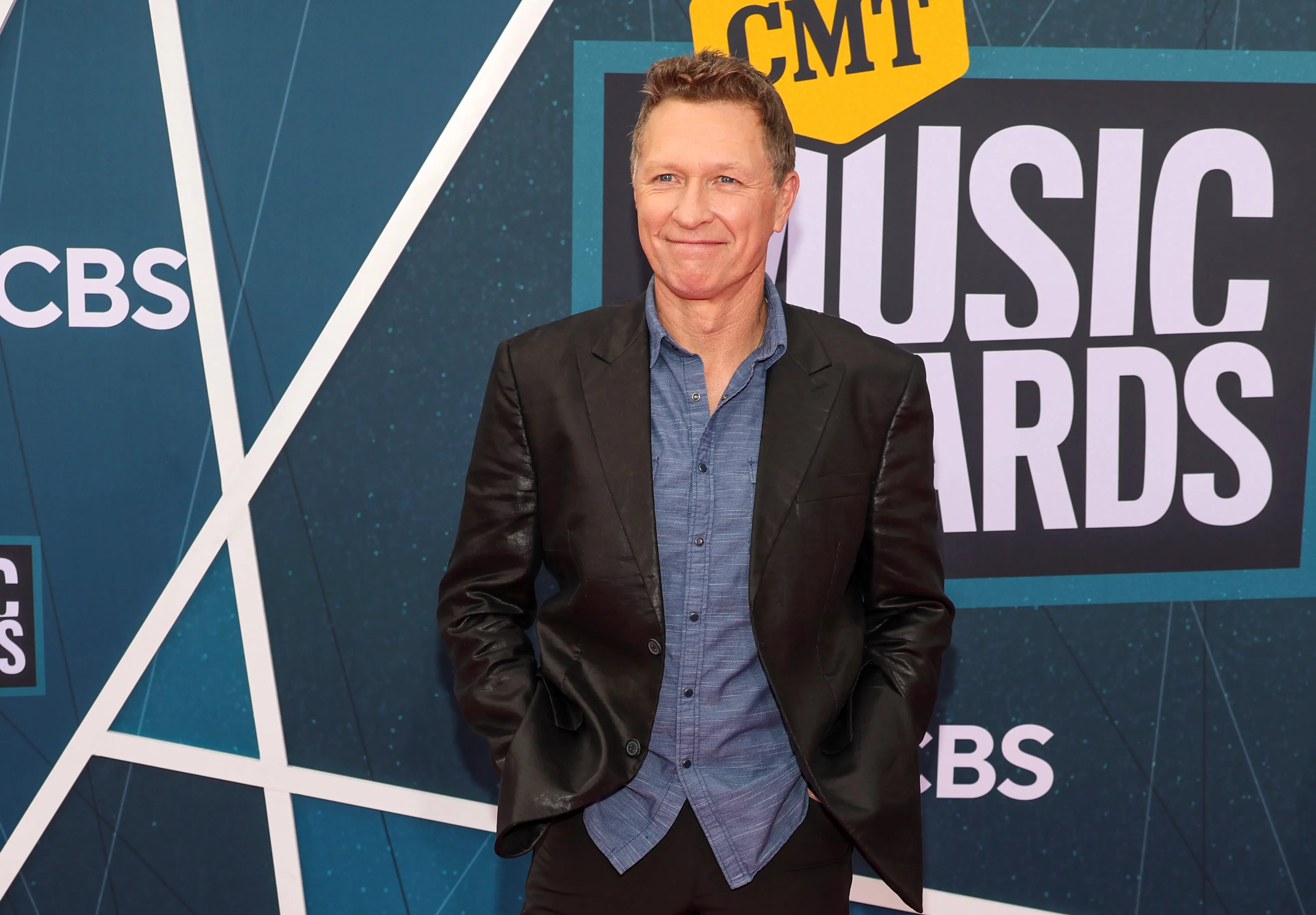 Craig Morgan wearing a suit jacket in from of CMT Music Awards signage