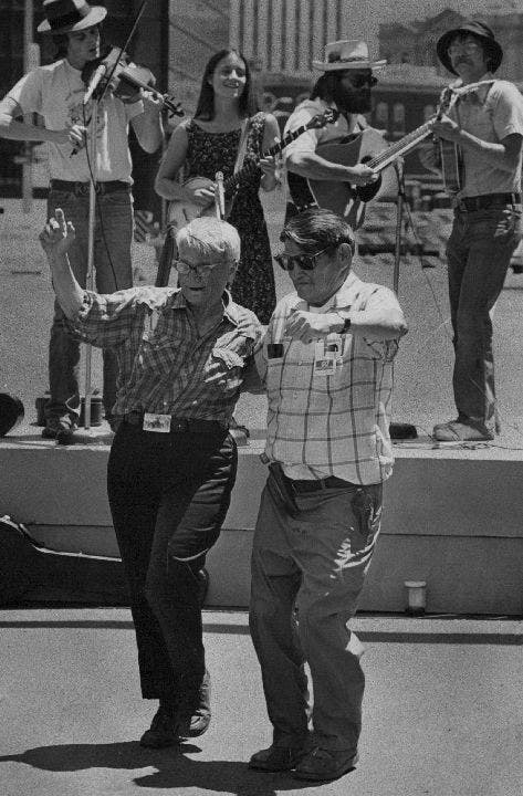 Two men dance while 4th of July band plays