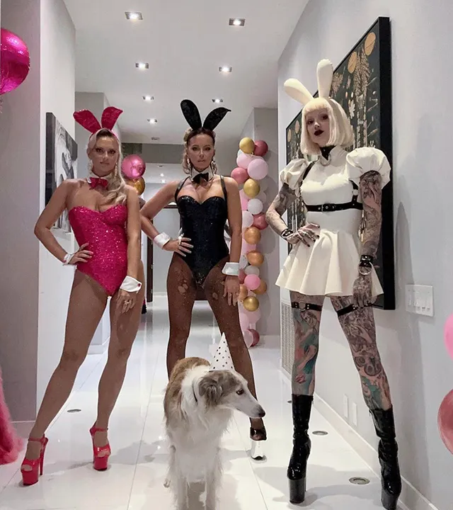 Kate Beckinsale puts her hands on hips while wearing "Playboy" bunny outfit surrounded by friends in similar attire